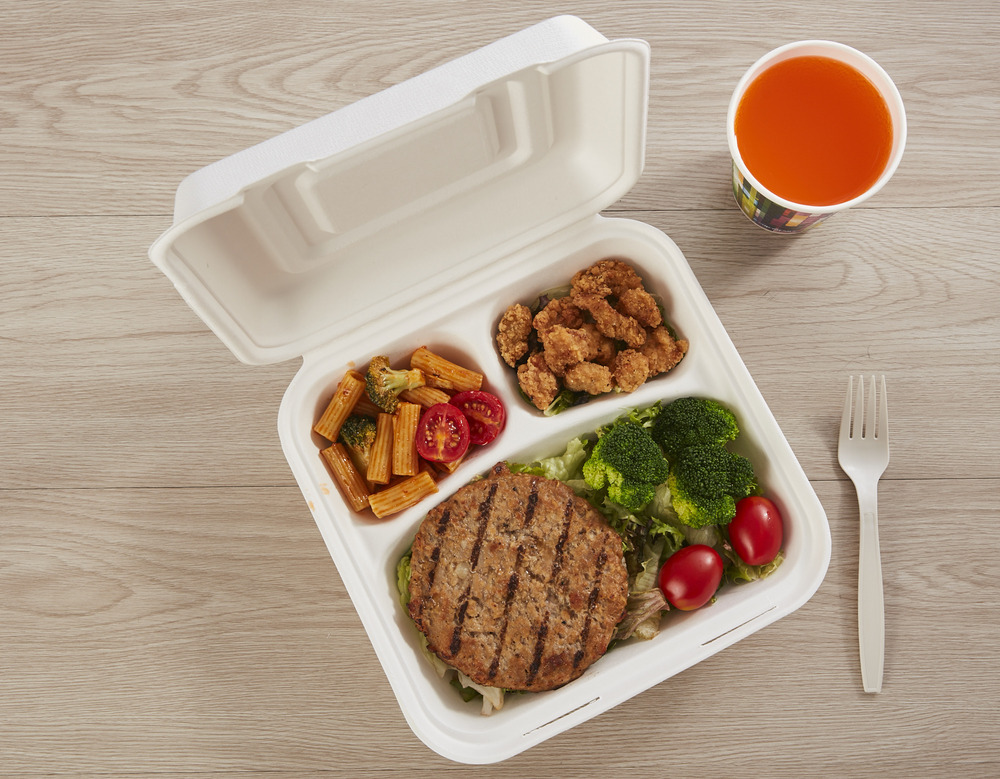 A delicious burger and fries served in a sugarcane bagasse clamshell